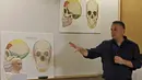 Liran Carmel menjelaskan model cetak 3D wajah gadis spesies manusia prasejarah Denisovan di Universitas Ibrani di Yerusalem (19/9/2019). Wajah gadis yang meninggal 40.000 tahun yang lalu di Siberia ini telah terungkap untuk pertama kalinya. (AFP Photo/Menahem Kahana)