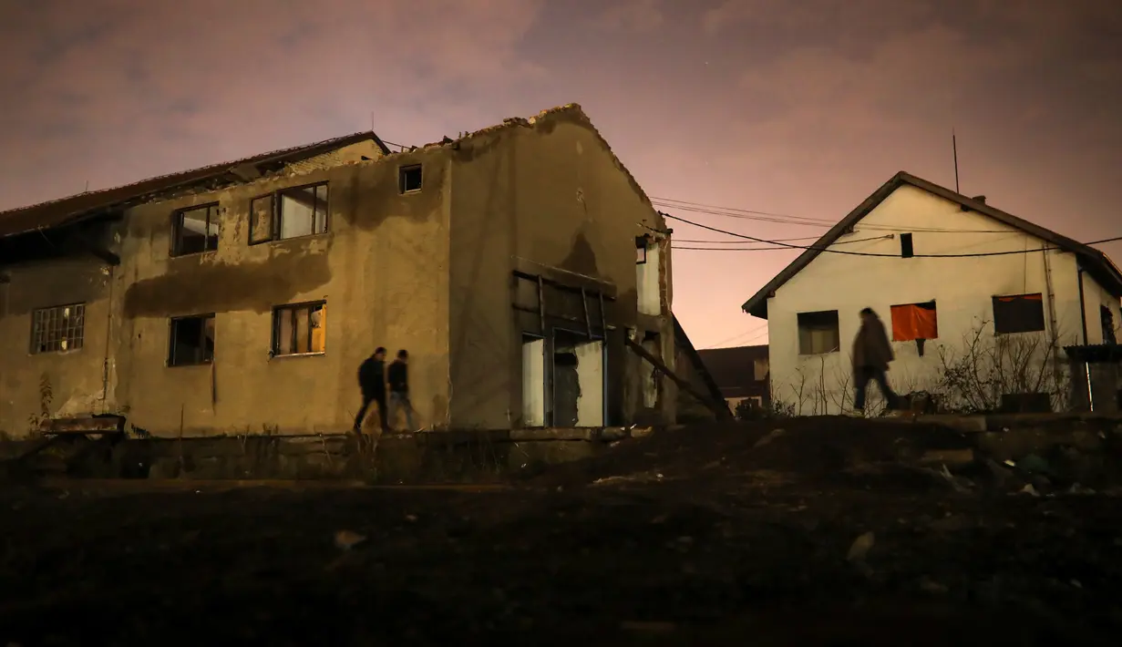 Imigran berjalan di luar sebuah gudang tak terpakai yang mereka jadikan tempat tinggal di Belgrade, Serbia, 17 November 2016. Menurut badan pengungsi PBB, sekitar 6.400 imigran saat ini terdaftar di Serbia. (REUTERS/Marko Djurica)