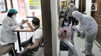 Suasana vaksinasi covid-19 Sinovac kepada warga di Polsek Pamulang, Tangerang Selatan, Kamis (1/7/2021). Sebanyak 10 ribu dosis vaksin untuk warga 18 tahun ke atas dibagikan di wilayah Polres Tangerang Selatan dalam rangka HUT Bhayangkara Ke-75 yang jatuh pada hari ini. (merdeka.com/Arie Basuki)