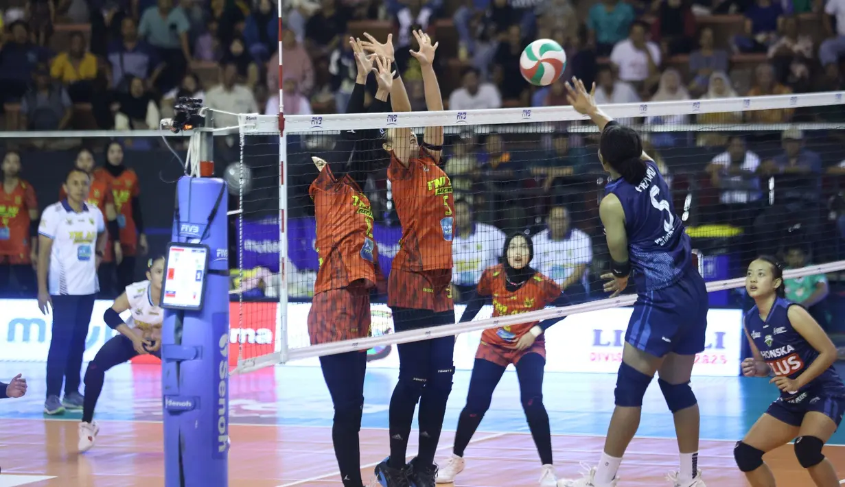 Pemain Petrokimia Gresik Pupuk Indonesia mencoba melakukan spike ke daerah TNI AU Electric pada Final Four Livoli Divisi Utama 2025 yang bertempat di GOR Ki Mageti, Magetan Rabu (15/10/2025).