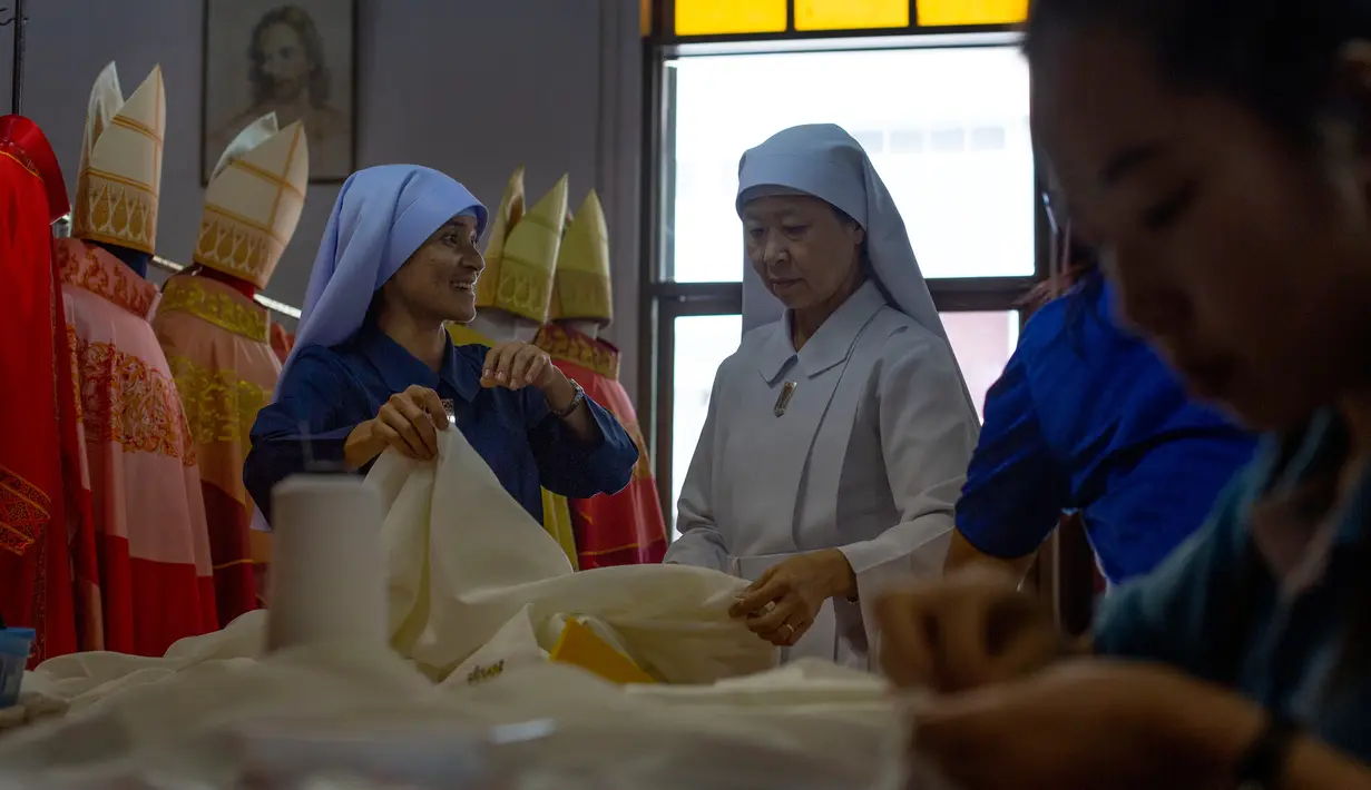 Penjahit menyelesaikan pembuatan jubah yang akan digunakan Paus Fransiskus saat mengunjungi Thailand, Bangkok, Jumat (8/11/2019). Jubah khusus yang akan dikenakan Paus Fransiskus terdiri dari dua set, emas-putih dan merah. (AP Photo/Gemunu Amarasinghe)