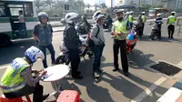 Sejumlah pengendara motor terkena tilang di sepanjang Jalan Jendral Sudirman, Jakarta, Sabtu (30/5/2015). Polisi menggelar razia patuh jaya untuk menertibkan para pengendara yang melanggar lalu lintas, mulai 27 Mei-9 Juni. (Liputan6.com/Yoppy Renato)