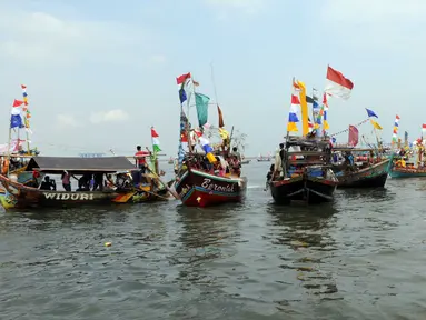 Para nelayan bersama keluarganya berlayar untuk mengikuti sedekah bumi Nadran di Muara Angke, Jakarta, Minggu (13/12). Tradisi ini diikuti ratusan kapal dengan melarung dan memperebutkan sesaji di tengah laut. (Liputan6.com/Helmi Afandi)