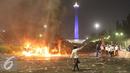 Sejumlah mobil dibakar pendemo saat terjadi bentrok dengan polisi di kawasan Monas, Jakarta, Jumat (4/11). Diduga bentrok terjadi saat massa HMI menyerang polisi dan polisi membalasnya dengan melempar gas air mata. (Liputan6.com/Immanuel Antonius)