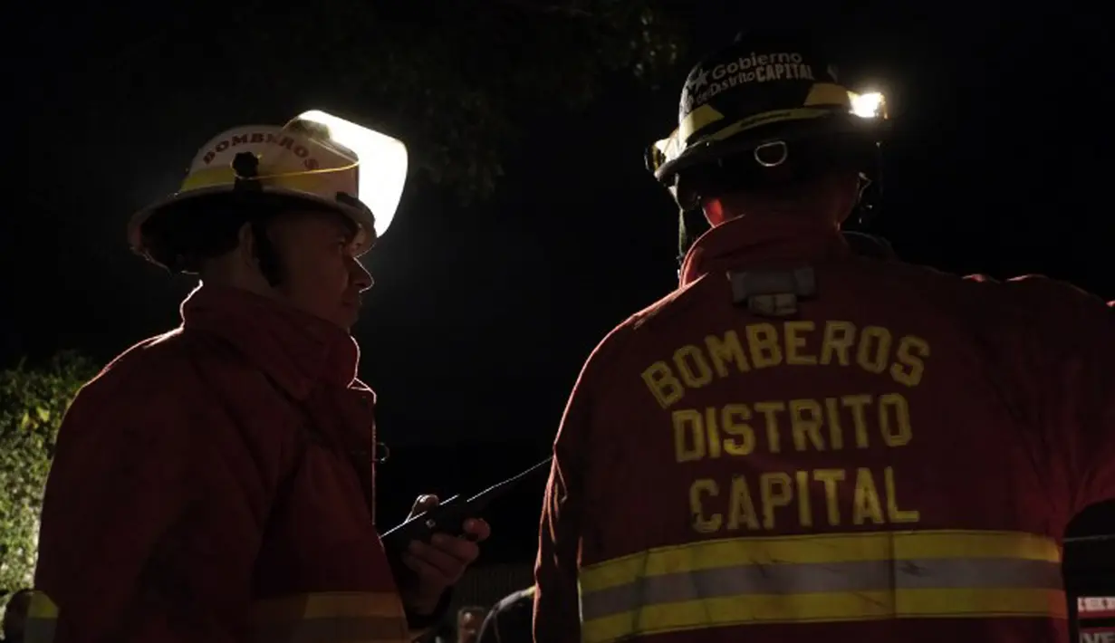 Petugas pemadam kebakaran berada di lokasi terjadinya kebakaran di sebuah panti jompo swasta di Caracas, Venezuela, Minggu (23/8/2015) waktu setempat. Delapan orang penghuni panti tewas dalam peristiwa tersebut. (AFP PHOTO/JUAN BARRETO)