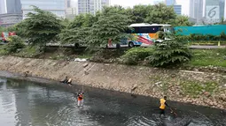 Petugas membersihkan sampah yang mengotori Kali Cideng, Jakarta, Minggu (23/7). Kurangnya kesadaran warga akan kebersihan membuat kali di Ibu Kota banyak dipenuhi sampah, terutama limbah rumah tangga. (Liputan6.com/Immanuel Antonius)