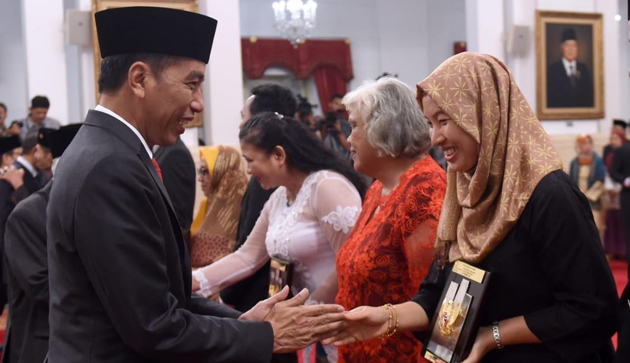 Presiden Joko Widodo (kiri) memberikan gelar Pahlawan Nasional kepada ahli waris di Istana Negara, Jakarta, Jumat (8/11/2019). Jokowi memberikan gelar Pahlawan Nasional kepada enam tokoh yang dianggap berjasa untuk Indonesia. (Foto: Lukas-Biro Pers Sekretariat Presiden)