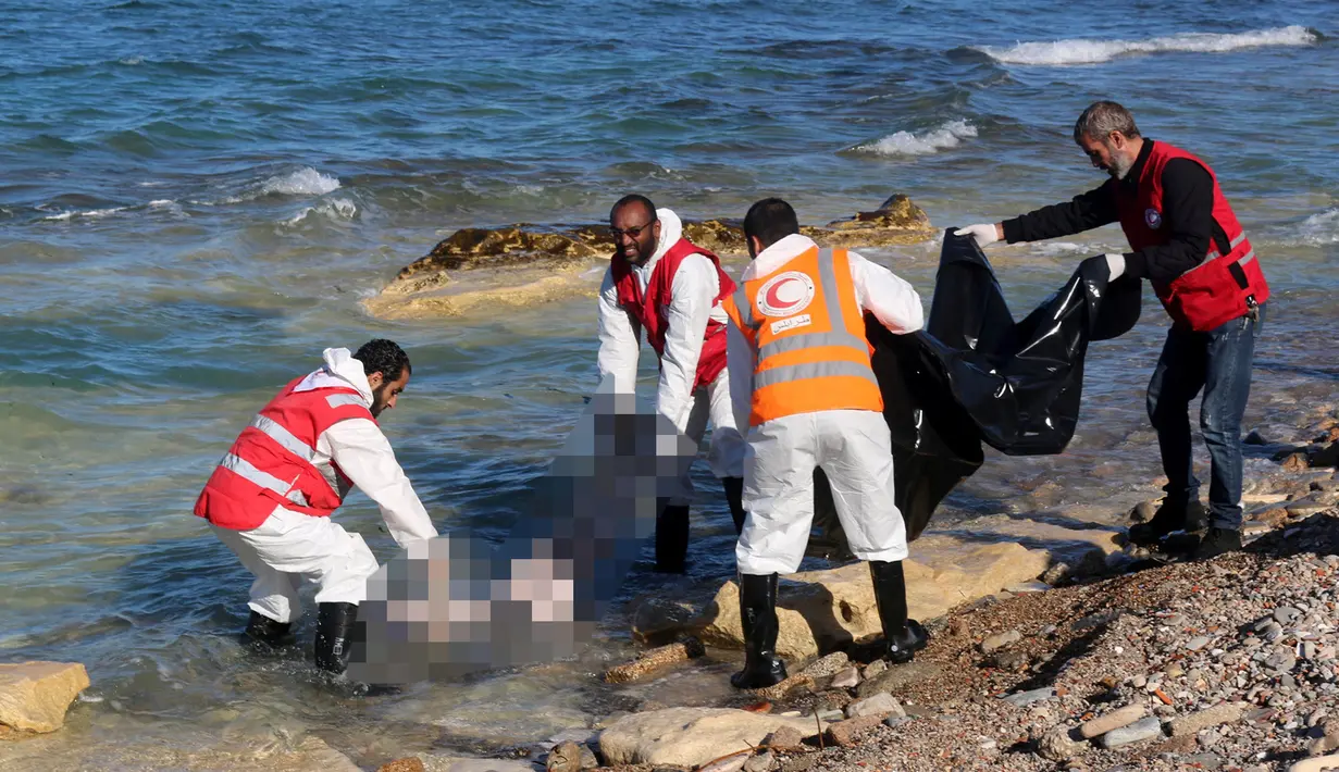 Petugas mengangkat mayat yang terapung di pantai di Kota Pesisir Tajoura, Libya, Minggu (4/12). Diduga orang yang tenggelam itu akan meninggalkan Libya karena berharap dapat menjadi imigran di negara lain. (REUTERS / Hani Amara)