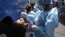 Petugas medis mengambil sampel untuk tes PCR COVID-19 di sebuah pasar di Lima, Peru, Rabu (5/1/2022). Peru mengonfirmasi pada Selasa dimulainya gelombang ketiga infeksi virus corona di mana negara itu mencatat 309 kasus varian omicron yang sangat menular. (AP Photo/Martin Mejia)