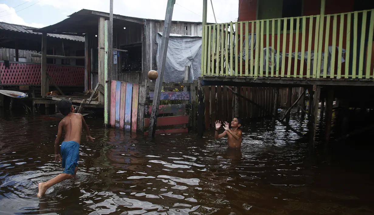 <p>Anak-anak bermain di jalan yang dibanjiri oleh naiknya sungai Negro di Iranduba, negara bagian Amazonas, Brasil, Senin (23/5/2022). Wilayah Amazon sedang dilanda banjir dengan 35 kotamadya yang menghadapi salah satu banjir terburuk mereka dalam beberapa tahun dan permukaan air diperkirakan akan meningkat selama beberapa bulan mendatang. (AP Photo/Edmar Barros)</p>