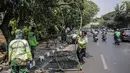 Petugas Suku Dinas Kehutanan Jakarta Pusat mengangkut pagar yang dirusak pengunjuk rasa usai demonstrasi di depan TPU Karet, Jakarta, Selasa (1/10/2019). Pengerusakan dilakukan pengunjuk rasa saat terlibat bentrok dengan polisi di kawasan tersebut. (Liputan6.com/Faizal Fanani)