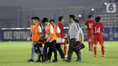 Pemain Timnas Indonesia U-19, M Supriadi ditandu keluar lapangan akibat cedera saat melawan Hong Kong pada laga kualifikasi Grup K Piala AFC U-19 2020 di Stadion Madya Gelora Bung Karno, Jakarta, Jumat (8/11/2019). Indonesia unggul 4-0. (Liputan6.com/Helmi Fithriansyah)