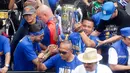 Pemain Persib Bandung, Dedi Kusnandar, mengangkat trofi saat pawai juara di Bandung, Minggu (25/5/2025). (Bola.com/M Iqbal Ichsan)