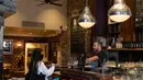 Seorang staf (kanan) berbicara dengan pelanggan di Caffe Nero yang dibuka kembali untuk layanan dibawa pulang di Maida Vale di London (10/6/2020). Beberapa kedai kopi di Inggris telah dibuka kembali untuk pengiriman atau layanan takeaway dengan mengikuti aturan jaga jarak sosial. (Xinhua/Han Yan)