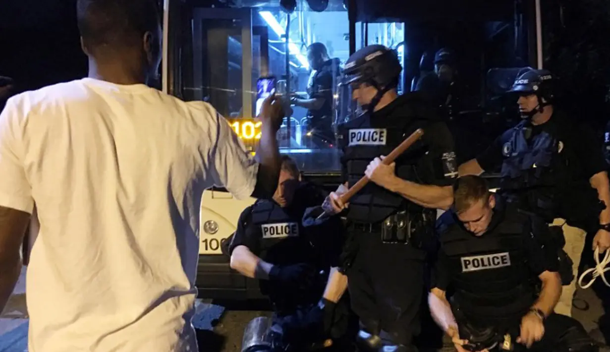 Sekitar 12 polisi dikabarkan terluka akibat bentrok yang terjadi saat unjuk rasa memprotes penembakan warga kulit hitam di North Carolina, AS, Selasa (20/9). (REUTERS/Adam Rhew)