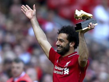 Penyerang Liverpool, Mohamed Salah, mengangkat trofi Sepatu Emas Premier League usai laga melawan Brighton & Hove Albion di Stadion Anfield, Minggu (13/5/2018). Salah menjadi top scorer Premier League dengan raihan 32 gol. (AP/Dave Thompson)