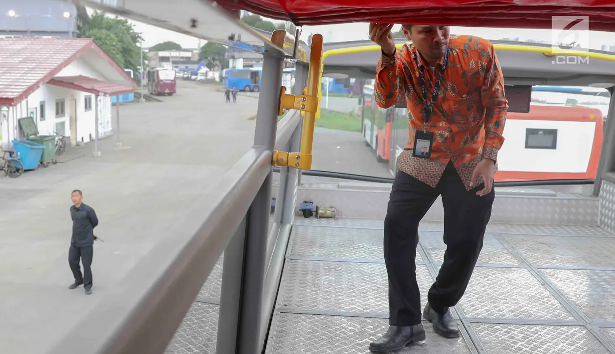Petugas mengecek bus transjakarta yang akan digunakan untuk pawai kemenangan tim sepak bola Persija Jakarta di kantor PT Transjakarta, Cawang, Kamis (13/12). Bus tersebut akan digunakan untuk pawai kemenangan Persija. (Liputan6.com/Immanuel Antonius)