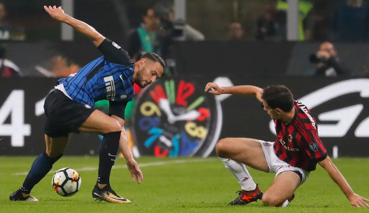 Pemain Inter Milan, Danilo D'Ambrosio berebut bola dengan pemain AC Milan, Giacomo Bonaventura pada pekan kedelapan Liga Italia di Stadion Giuseppe Meazza, Minggu (15/10). Gol Inter Milan diborong oleh Mauro Icardi, 3-2. (AP/Antonio Calanni)