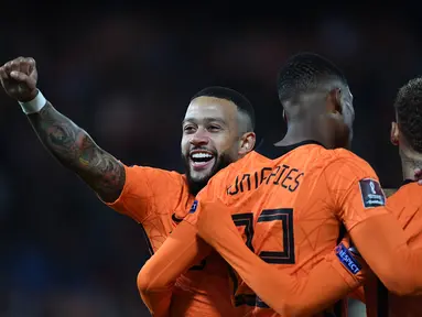 Pemain depan Belanda Memphis Depay berselebrasi dengan Denzel Dumfries setelah mencetak gol ke gawang Gibraltar pada laga Kualifikasi Piala Dunia 2022 zona Eropa Grup G di De Kuip, Rotterdam, Selasa (12/10/2021) dini hari WIB. Menjamu Gibraltar, Belanda menang 6 gol tanpa balas. (JOHN THYS/AFP)