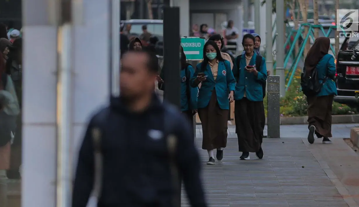 Seorang pelajar berjalan mengenakan masker pelindung untuk menghindari polusi udara buruk di Jakarta, Rabu (17/7/2019). Dinkes DKI menyarankan masyarakat untuk menggunakan masker saat beraktivitas untuk mencegah dampak polusi udara pada tubuh. (Liputan6.com/Faizal Fanani)