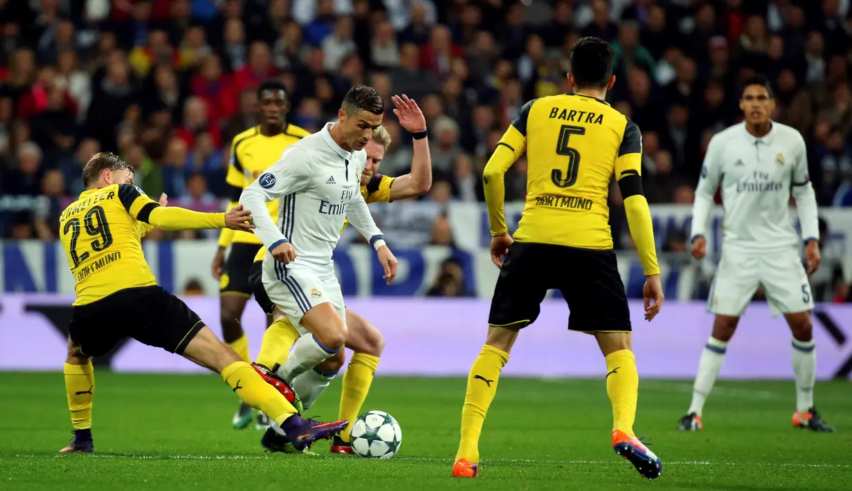 Gelandang Real Madrid, Cristiano Ronaldo berusaha melewati para pemain Borussia Dortmund pada pertandingan Grup F Liga Champions di Santiago Bernabeu, Madrid, (8/12). Real Madrid bermain imbang 2-2 dengan Dortmund. (REUTERS/Susana Vera)