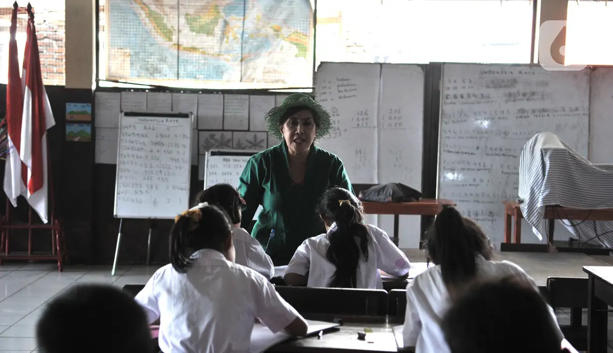Sri Irianingsih mengajar siswa Sekolah Darurat Kartini di kawasan Lodan, Jakarta Utara, Senin (25/11/2019). Sri Rossyati dan Sri Irianingsih mengaku ini berawal dari keprihatinan membantu anak-anak kurang mampu untuk bersekolah karena terganjal masalah administratif. (merdeka.com/Iqbal Nugroho)