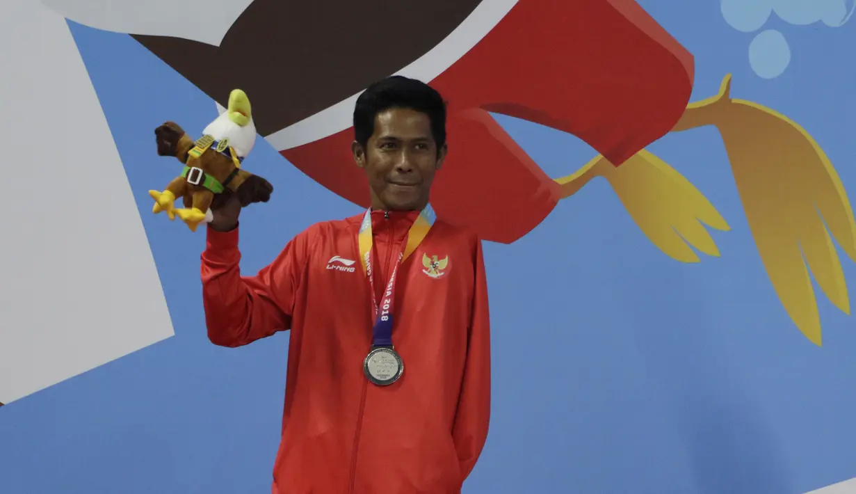 Perenang Indonesia, Guntur, melakukan selebrasi pada Asian Para Games di Stadion Aquatik, Jakarta, Selasa (9/10/2018). Indonesia meraih medali perak dan perunggu di nomor 100 meter gaya dada putra kategori SB8. (Bola.com/M Iqbal Ichsan)