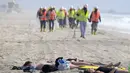 Pekerja berjalan saat pengunjung pantai beristirahat di Huntington Beach, California, Senin (11/10/2021). Pantai Huntington membuka kembali garis pantainya setelah hasil pengujian air kembali dengan jumlah racun terkait minyak yang tidak terdeteksi di air laut. (AP Photo / Ringo HW Chiu)