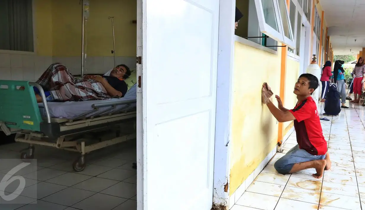 Pasien menjalani perawat saat relawan membersihkan sisa lumpur yang menggenangi RSUD dr Slamet akibat banjir bandang di Kabupaten Garut, Kamis (22/9). Pasca diterjang banjir bandang, peralatan perlengkapan RSUD dr Slamet rusak. (Liputan6.com/Johan Tallo)