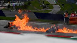 Kobaran api timbul usai tabrakan antara pembalap tim Aprilia Gresini, Lorenzo Savadori dengan Dani Pedrosa dari tim KTM Red Bull saat balapan memasuki lap ketiga. (Foto: AFP/Joe Klamar)