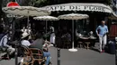 Orang-orang duduk di teras Cafe de Flore di Paris, Selasa (2/6/2020). Warga Paris terkurung selama berbulan-bulan karena lockdown Corona namun, kini sebagian kafe dan restoran di kota itu dibuka kembali usai pelonggaran pembatasan. (AP Photo/Christophe Ena)