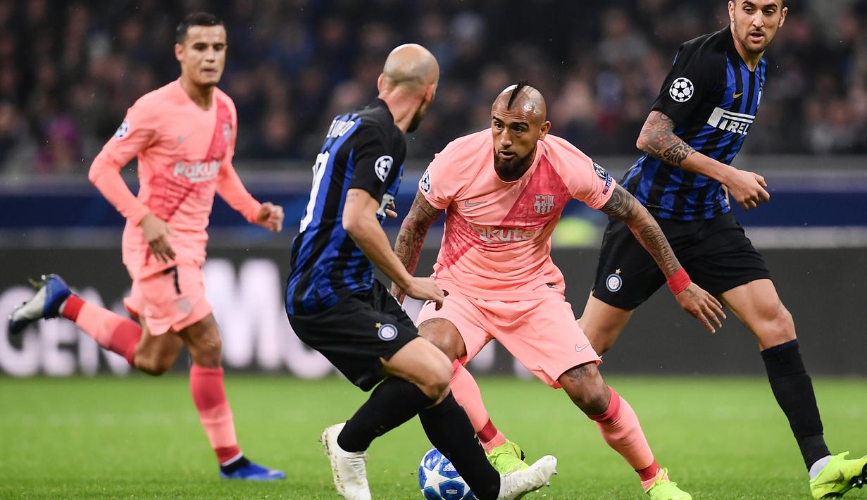 Gelandang Barcelona, Arturo Vidal, berusaha melewati gelandang Inter Milan, Matias Vecino, pada laga Liga Champions di Stadion San Siro, Milan, Selasa (6/11). Kedua klub bermain imbang 1-1. (AFP/Marco Bertorello)