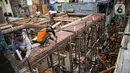 Para pekerja menyelesaikan pembangunan rumah panggung di dekat bantaran Kali Ciliwung, Kampung Melayu, Jakarta, Rabu (7/4/2021). Pemerintah Provinsi DKI Jakarta melakukan renovasi terhadap 40 hunian warga Kampung Melayu menjadi rumah panggung. (Liputan6.com/Faizal Fanani)