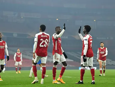 Gelandang Arsenal, Nicolas Pepe (ketiga kanan) berselebrasi dengan rekan-rekannya usai mencetak gol ke gawang Molde pada pertandingan grup B Liga Europa di Emirates Stadium di London (5/11/2020). Arsenal menang telak atas Molde 4-1. (AFP/Glyn Kirk)
