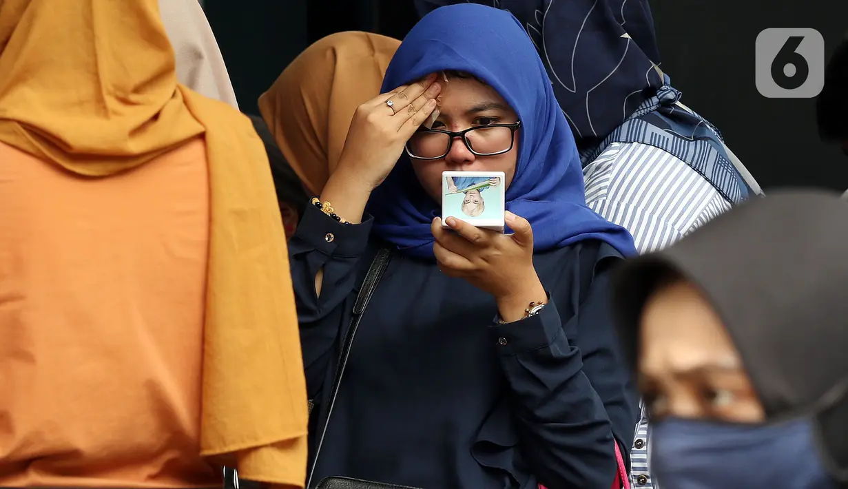 Seorang pencari kerja merias wajahnya sebelum pada acara Job Fair di kawasan Jakarta, Rabu (27/11/2019). Job Fair tersebut digelar dengan menawarkan lowongan berbagai sektor untuk mengurangi angka pengangguran. (Liputan6.com/Johan Tallo)