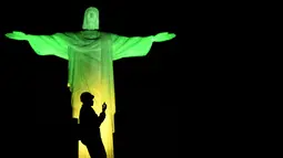 Dekorasi lighting patung Jesus oleh seniman Prancis Gaspare Di Caro beberapa menit sebelum pembukaan Olimpade Rio 2016 di Rio de Janeiro.(AFP/Jeff Pachoud)