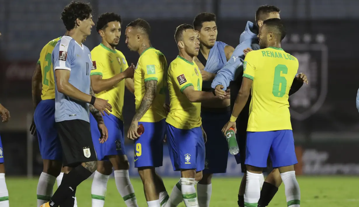 Pemain Brasil bersalaman dengan pemain Uruguay usai pertandingan keempat kualifikasi Piala Dunia 2022 zona CONMEBOL di Estadio Centenario, Montevideo, Selasa (17/11/2020). Brasil menang atas Uruguay 2-0. (Raul Martinez / Pool via AP)
