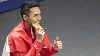 Pebulutangkis Indonesia, Jonatan Christie, menggigit medali usai final tunggal putra bulutangkis di Istora Senayan, Selasa (28/8/2018). Jonatan menang 21-18, 20-22, 21-15 atas wakil China Taipei, Chou Tien Chen. (Bola.com/Peksi Cahyo)