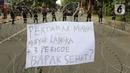 Sebuah poster diletakkan pada kawat berduri yang menjadi barikade saat aksi demo mahasiswa di kawasan Patung Kuda, Jakarta, Senin (4/11/2022). Mereka menyampaikan tuntutannya terkait kenaikan minyak goreng dan bahan bakar minyak (BBM). (Liputan6.com/Herman Zakharia)