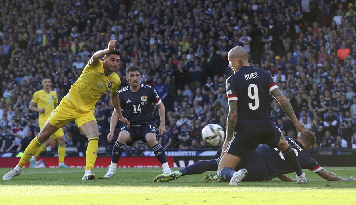 Pemain Skotlandia Lyndon Dykes (kanan) mencoba untuk memblokir tendangan pemain Ukraina Roman Yaremchuk (kiri) pada pertandingan play-off kualifikasi Piala Dunia 2022 di Hampden Park Stadium, Glasgow, Skotlandia, 1 Juni 2022. Ukraina menang 3-1. (AP Photo/Scott Heppell)