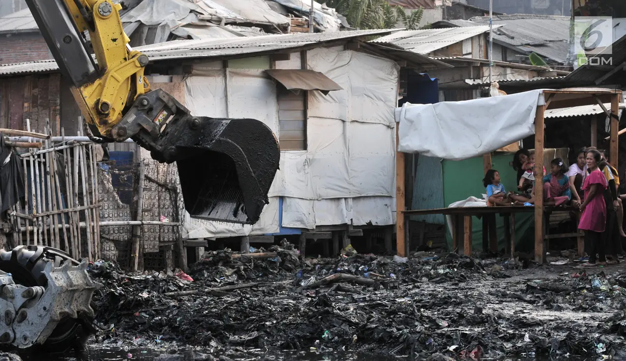Warga menyaksikan petugas UPK Badan Air Dinas Lingkungan Hidup DKI Jakarta membersihkan sampah di Kampung Bengek, Muara Baru, Penjaringan, Jakarta, Rabu (4/9/2019). Setelah viral, lautan sampah yang memenuhi tanah garapan milik PT Pelindo II tersebut mulai dibersihkan. (merdeka.com/Iqbal Nugroho)