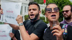 Seorang wanita Tunisia memegang sebatang merokok selama protes terhadap pemilik restoran dan bar yang menutup tokonya selama puasa bulan suci Ramadan di Tunis, Tunisia, (27/5). (AP Photo / Hassene Dridi)