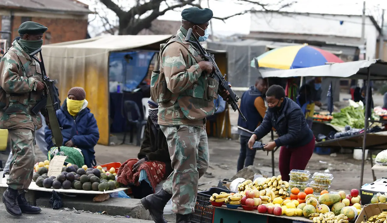 Tentara Angkatan Pertahanan Afrika Selatan berpatroli di Alexandra, ohannesburg, Kamis (15/7/2021). Pasukan tersebut dikerahkan untuk membantu memadamkan kerusuhan dan penjarahan selama seminggu yang dipicu oleh pemenjaraan mantan Presiden Jacob Zuma. (AP Photo)