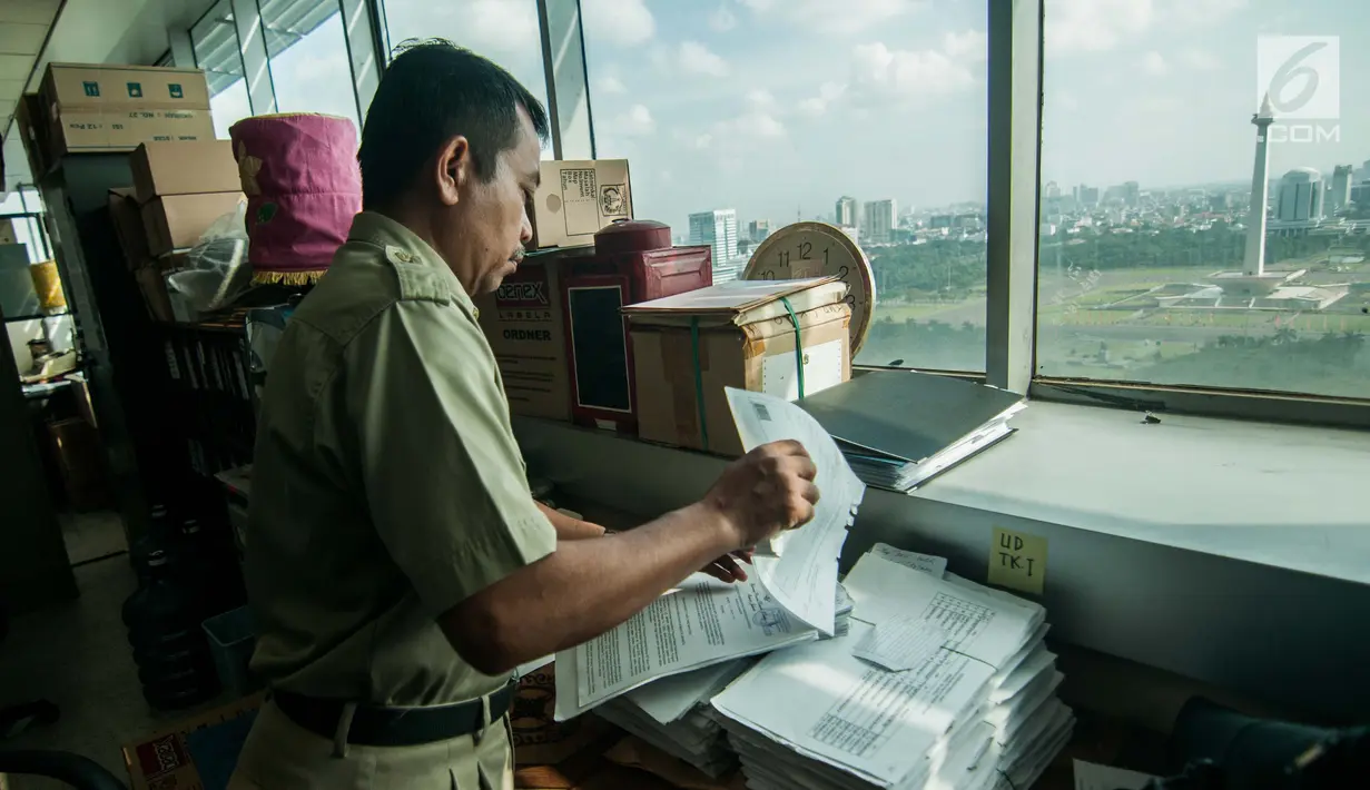 Seorang pegawai Pemerintahan Provinsi DKI Jakarta mencari berkas di Balai Kota, Jakarta, Senin (3/7). Pasca libur Lebaran seluruh PNS Pemprov DKI terlihat masuk kerja kembali seperti biasanya. (Liputan6.com/Gempur M Surya)