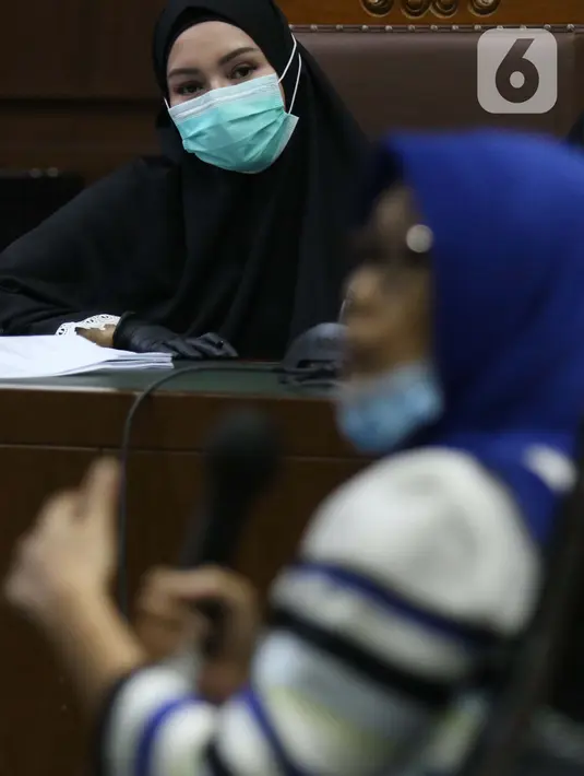 Terdakwa dugaan suap dan tindak pidana pencucian uang terkait pengurusan fatwa Mahkamah Agung, Pinangki Sirna Malasari menyimak kesaksian mantan kuasa hukum Djoko S Tjandra Anita Kolopaking saat sidang lanjutan di Pengadilan Tipikor Jakarta, Rabu (25/11/2020). (Liputan6.com/Helmi Fithriansyah)