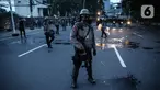Anggota brimob memukul mundur massa aksi di kawasan Tanah Abang, Jakarta, Selasa (13/10/2020). Hingga menjelang magribh massa masih melakukan perlawan di kawasaan tersebut. (Liputan6.com/Faizal Fanani)
