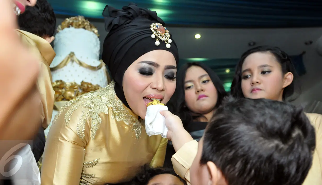 Muzdalifah tampak disuapi potongan kue oleh sang anak saat perayaan ulang tahunnya yang ke-37 tahun di kawasan Pramuka, Jakarta Timur, Senin (15/6/2015). (Liputan6.com/Panji Diksana)