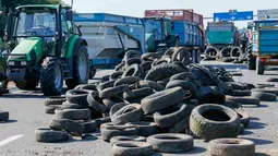 Petani Perancis memblokir jalan raya A6 dengan traktor dan ban di Limonest, dekat Lyon, Prancis (23/7/2015). Petani Perancis memprotes kembali ketidak seimbangan keuntungan yang diperoleh antara petani dan pengecer. (REUTERS/Robert Pratta)