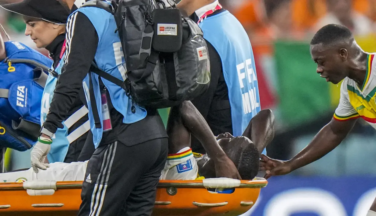 Gelandang Senegal #08 Cheikhou Kouyate dibawa menggunakan tandu setelah mengalami insiden dengan gelandang Belanda, Frenkie de Jong pada pertandingan kedua Grup A Piala Dunia 2022 di Stadion Al-Thumama di Doha, Senin (21/11/2022). Beberapa pemain Senegal tampak coba memberi semangat kepadanya. (AP Photo/Luca Bruno)