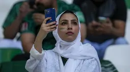 Seorang fans Arab Saudi menggunakan ponselnya menjelang pertandingan grup C Piala Dunia antara Polandia dan Arab Saudi, di Education City Stadium di Al Rayyan, Qatar, Sabtu, 26 November 2022. (AP Photo/Darko Vojinovic)